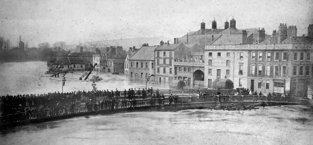 Crowds gather on a bridge to witness flooding